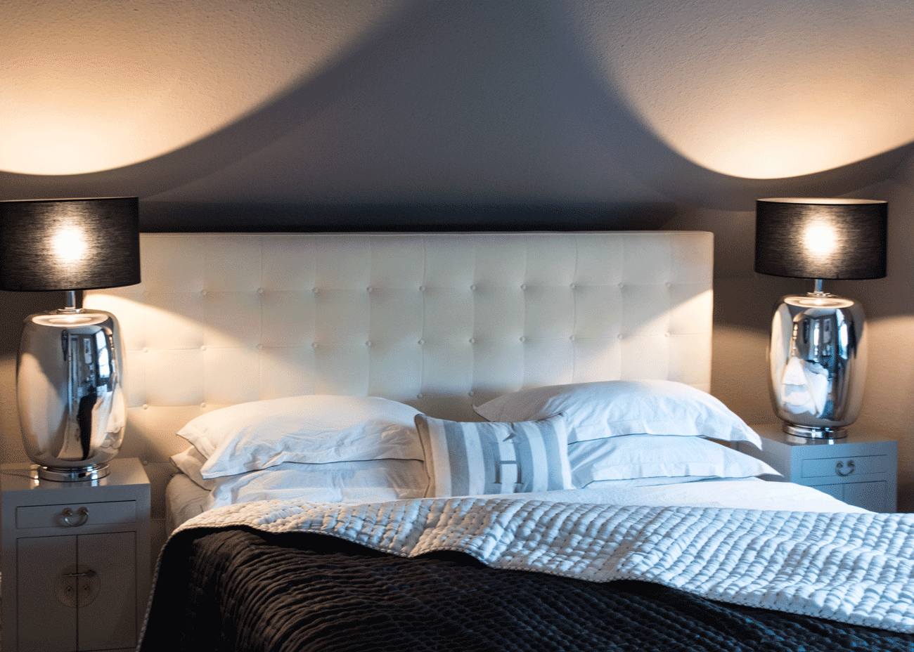 Wohnung renovieren schlafzimmer bett weiss dunkle wandfarbe leuchten schwarz kissen weiss