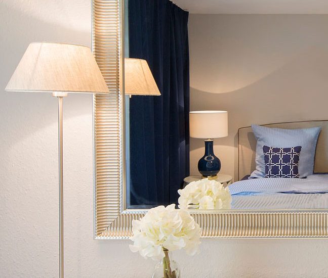 Wohnung gemülich einrichten Bett kissen blau leuchte spiegel