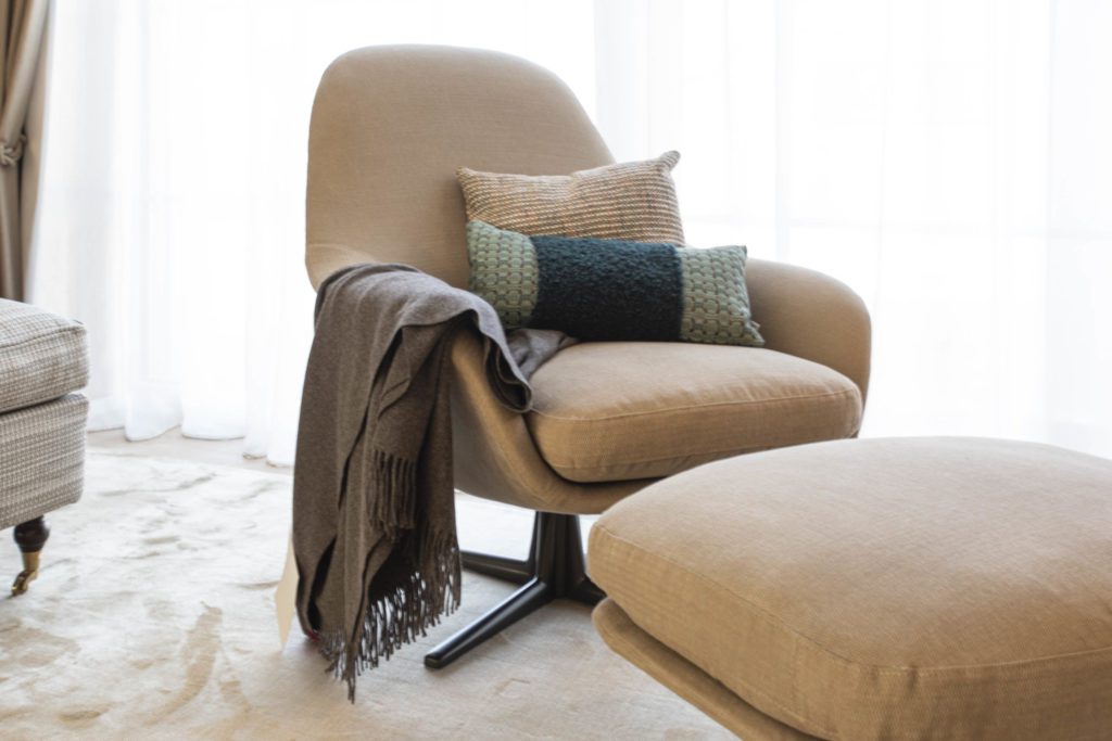 Farbkonzept Wohnzimmer Sessel mit hocher in beige mit hellem teppich